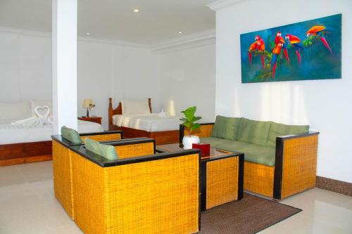a living room with wicker chairs and a couch at The Blanc Residence in Siem Reap