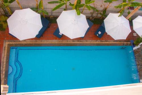 a group of umbrellas above a swimming pool at The Blanc Residence in Siem Reap