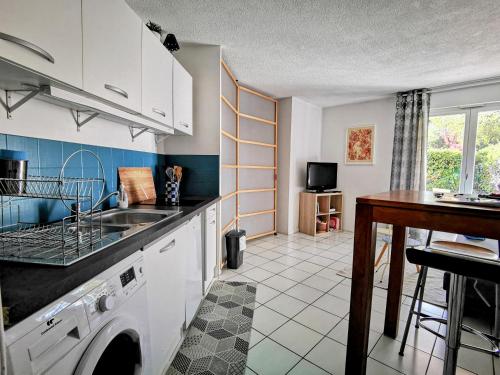 uma cozinha com um lavatório e uma máquina de lavar roupa em La Bulle Bleue - Parking-Terrasse-aéoport-MEET em Blagnac
