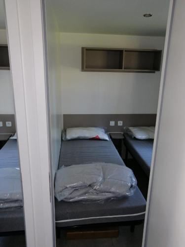 Cette petite chambre comprend 2 lits. dans l'établissement Mobilhome 6/8 personnes Piriac sur Mer, à Piriac-sur-Mer