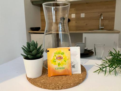 a table with a glass vase and a box and a plant at Florimond cosy apparts in Saint-Quentin