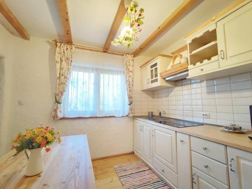 a kitchen with white cabinets and a table and a window at La sat in Bertea