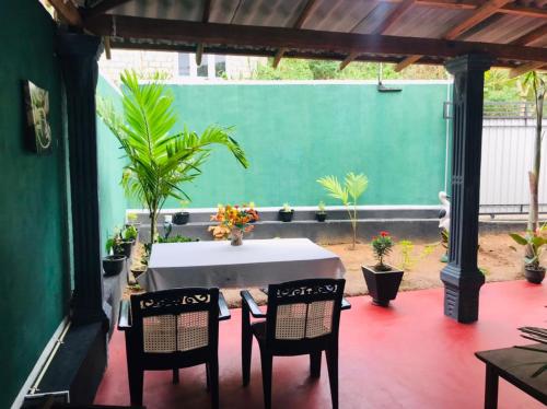 een tafel en stoelen op een patio met planten bij Kavidi Villa Home Stay in Tangalle