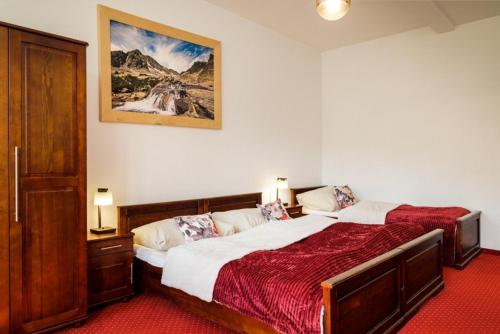 a bedroom with a bed and a picture on the wall at Penzion Zora Family in Vysoke Tatry - Tatranska Lomnica.