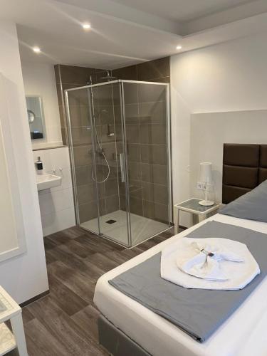 a bathroom with a shower and a bed with a towel at Hotel Leitner in Kaufbeuren