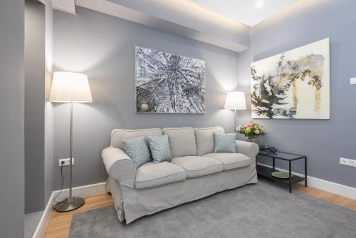 a living room with a white couch and two paintings at Charming apartment in Kolonaki in Athens