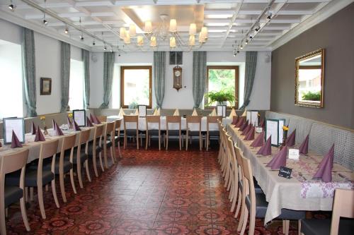 een feestzaal met tafels en stoelen en een kroonluchter bij Landhotel St. Florian in Sankt Florian am Inn