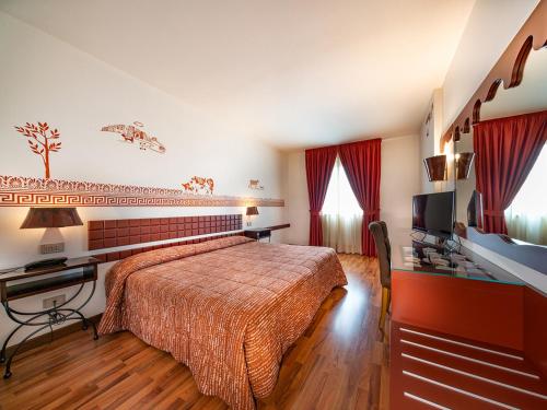 um quarto com uma cama, uma secretária e uma televisão em Chocohotel em Perugia