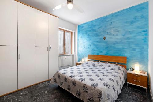 une chambre avec un lit et un mur bleu dans l'établissement Appartamento Le Vele, à Borghetto Santo Spirito