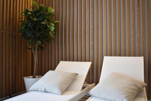 2 camas blancas en una habitación con maceta en Aldeia Bianca Village, en Almenno San Salvatore