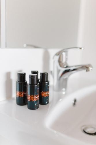 a bathroom counter with three bottles of essential oils next to a sink at Melivia Luxury Suite in Nikiana