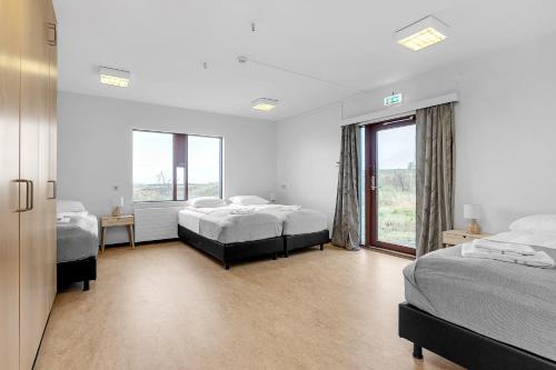sypialnia z 2 łóżkami i dużym oknem w obiekcie Víðines Guesthouse w Reykjavík