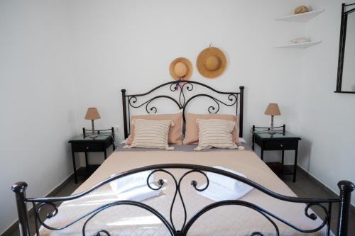 a bedroom with a black and white bed with pink pillows at Beachfront bungalow in the area of Kampi, near Koundouros in Ioulida