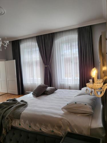 a bedroom with a large bed with two windows at Fancy Flats in Sibiu
