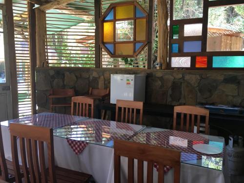a dining room with a table and chairs and windows at Hotel Faro del Valle in Pisco Elqui