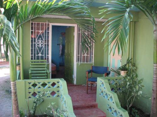 a man standing in the doorway of a house at T&T - Tatty and Tony Guesthouse in Negril