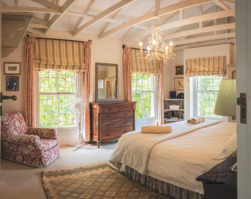 a bedroom with a large bed and a chandelier at The French Cottage in Clarens