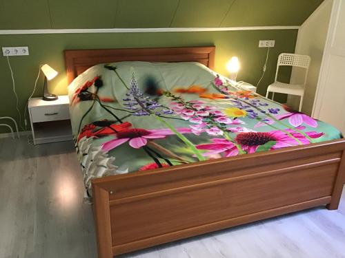 a bedroom with a bed with a floral bedspread at “In Oans Oefje” Parel in de polder! in Lewedorp