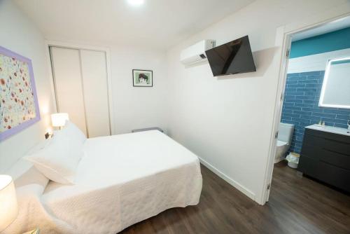een slaapkamer met een wit bed en een badkamer bij LAS DOS CATEDRALES 1 in Plasencia