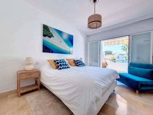 1 dormitorio con 1 cama grande y 1 sofá azul en Renovated 2 bedroom Apt 5 min walk to beach RDR279, en Estepona