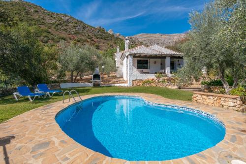 una piscina en un patio con una casa en El Chorro Villas Casa Rosaleda, en El Chorro