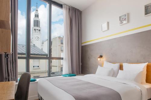 een hotelkamer met een bed en een groot raam bij Hotel Terre Neuve in Parijs