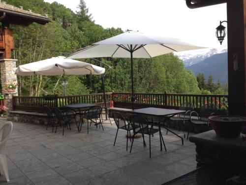 two tables and chairs with umbrellas on a patio at Les Combes in La Salle