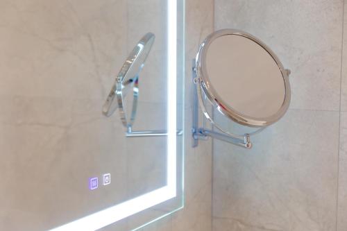 a mirror hanging on a wall next to a window at Muller Hotel Boutique & Spa in Galaţi