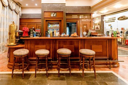 a bar in a restaurant with stools at Grand Hotel Pomorie - Medical spa in Pomorie
