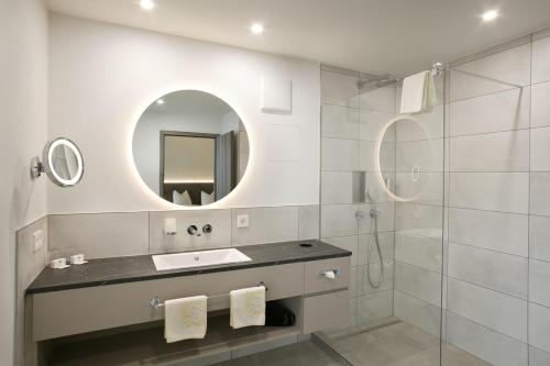 a bathroom with a sink and a mirror at Hotel & Restaurant Sonne in Rudersberg