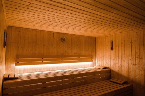 a wooden sauna with a bench in front of a window at Hotel Antoniushof in Ruhstorf