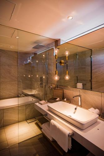 a bathroom with a tub and a sink and a mirror at MALIBU HOTEL in Zushi