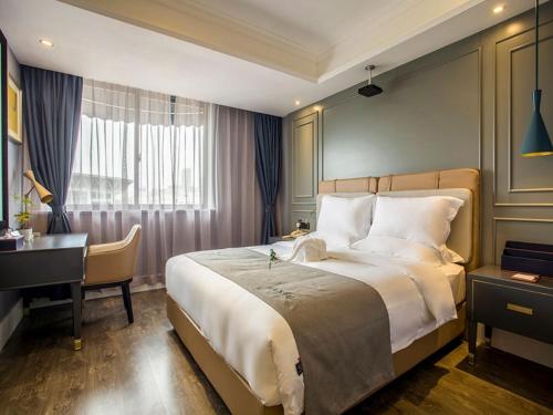 1 dormitorio con cama grande, escritorio y cama sidx sidx sidx sidx en LanOu Hotel Ningyang Qixian Road Yizhong, en Ningyang