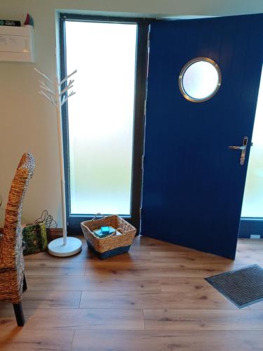 a blue door with a basket on a wooden floor at The Boathouse in Cork