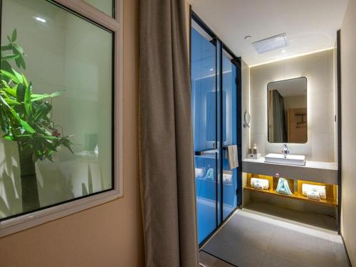 y baño con lavabo y espejo. en LanOu Hotel Lanzhou Zhengning Road Night Market en Lanzhou