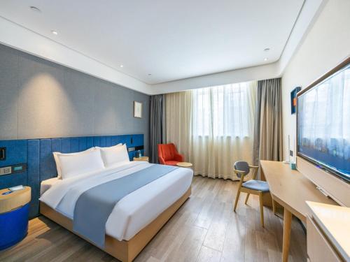 Habitación de hotel con cama grande y escritorio. en LanOu Hotel Lanzhou Zhengning Road Night Market en Lanzhou