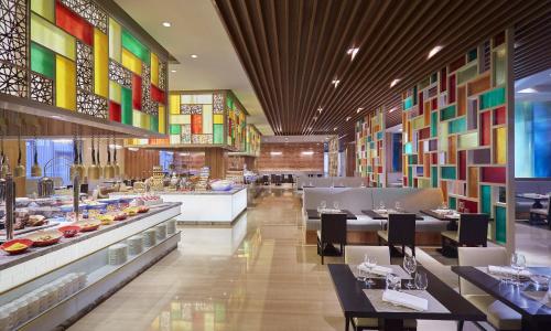 a restaurant with colorful walls and tables and chairs at Gran Melia Xi'an in Xi'an