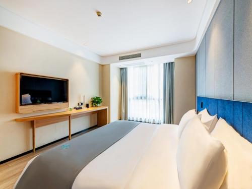 a large bedroom with a large bed and a tv at LanOu Hotel Zigong Yantan Longhu Food Plaza in Zigong