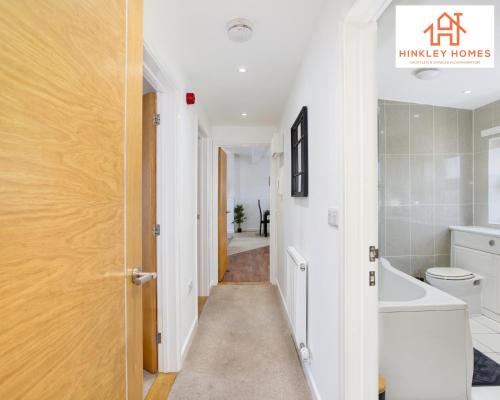 a hallway leading to a bathroom with a toilet and a sink at Flawless - City Centre - Free Parking - HPC - 5 - By Hinkley Homes Short Lets & Serviced Accommodation in Bridgwater