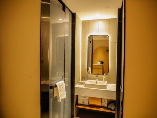 a bathroom with a sink and a mirror at LanOu Hotel Jinzhou Red Star Macalline in Jinzhou