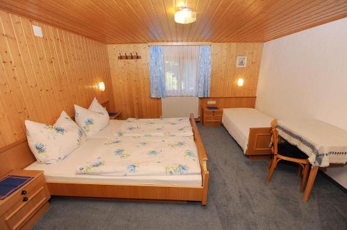 een slaapkamer met 2 bedden, een tafel en een raam bij Haus Tschambräu in Gaschurn