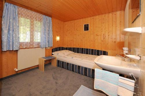 een kleine badkamer met een bed en een wastafel bij Haus Tschambräu in Gaschurn
