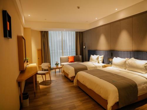 Cette chambre comprend deux lits et un bureau. dans l'établissement LanOu Hotel Jinzhou Red Star Macalline, à Jinzhou