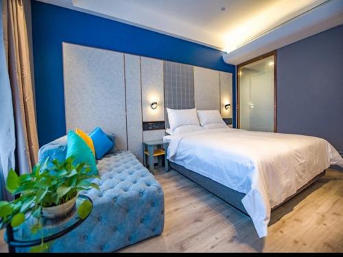 ein Schlafzimmer mit einem großen Bett und einer blauen Wand in der Unterkunft LanOu Hotel Heze Mudan District University Town in Heze