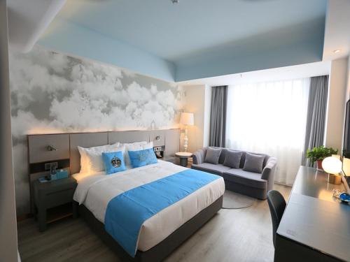 a hotel room with a large bed and a couch at LanOu Hotel Lianyungang Donghai Crystal City in Donghai