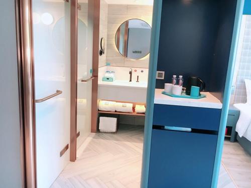 La salle de bains est pourvue d'un lavabo et d'un miroir. dans l'établissement LanOu Hotel Shaoguan University, à Shaoguan