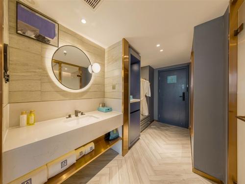 a bathroom with a large sink and a mirror at LanOu Hotel Linyi Lanshan Lushang Center Wanda Plaza in Linyi