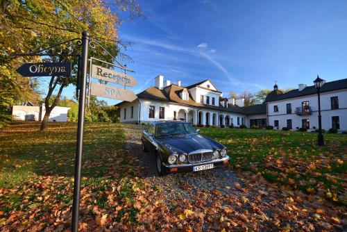 a car is parked in front of a street sign at Dwór Kombornia Hotel&SPA in Kombornia