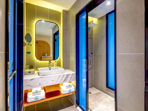 a bathroom with a sink and a mirror at LanOu Hotel Yangquan North Railway Station in Yu