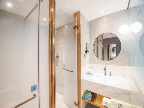 a bathroom with a sink and a mirror at LanOu Hotel Zhangye Hexi College Ganquan Park in Zhangye